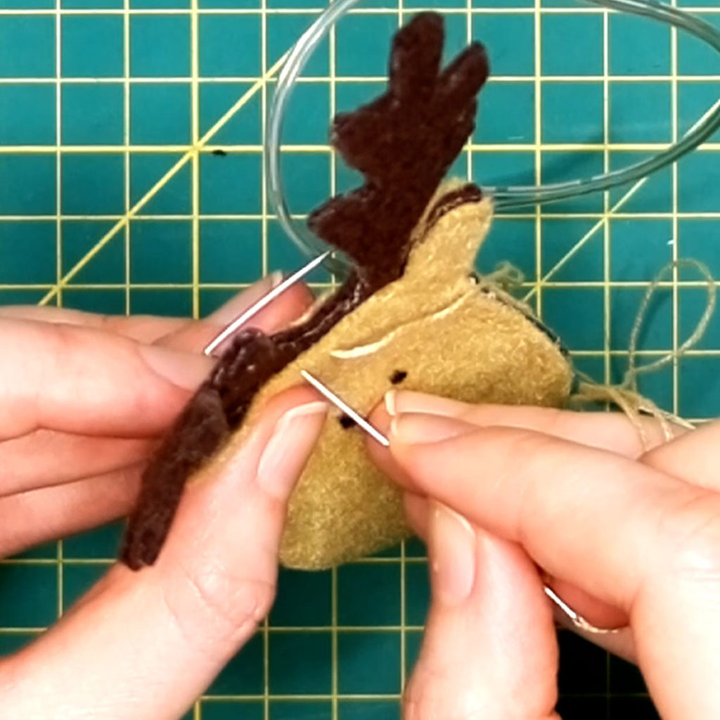 the front back and inside (antlers) pieces of felt are being sewn together with a chain stitch